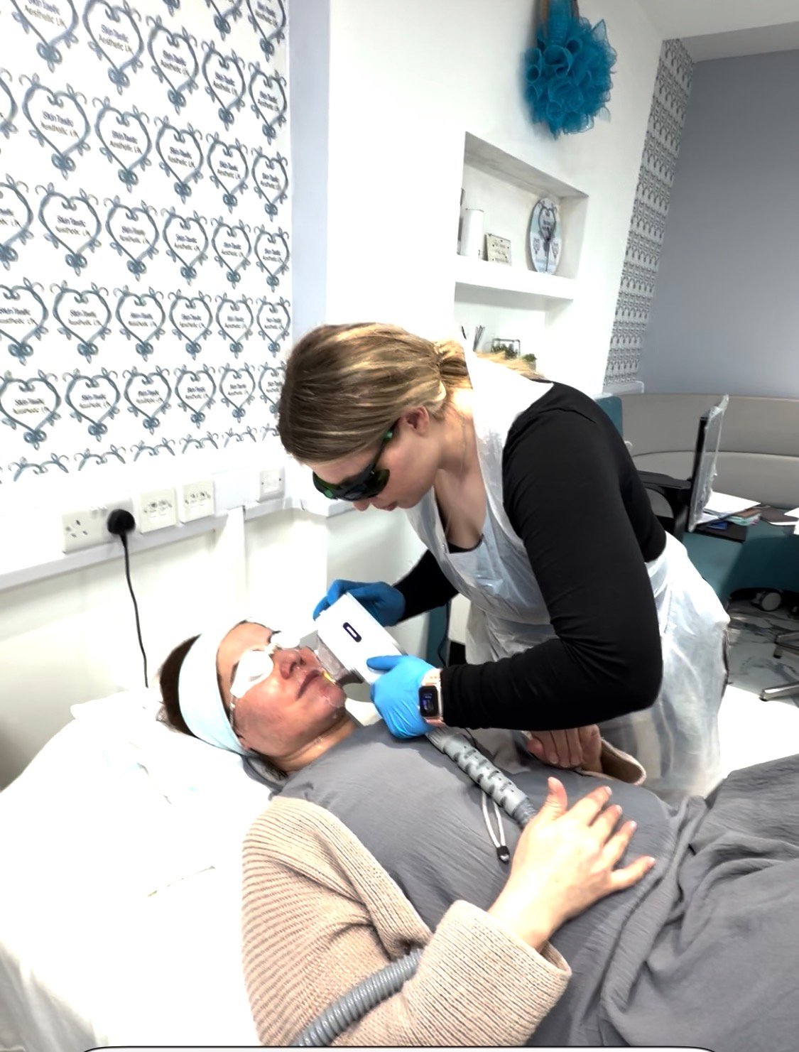 Laser Acne Therapy: practitioner treating a client in laser eyewear, gloves and apron