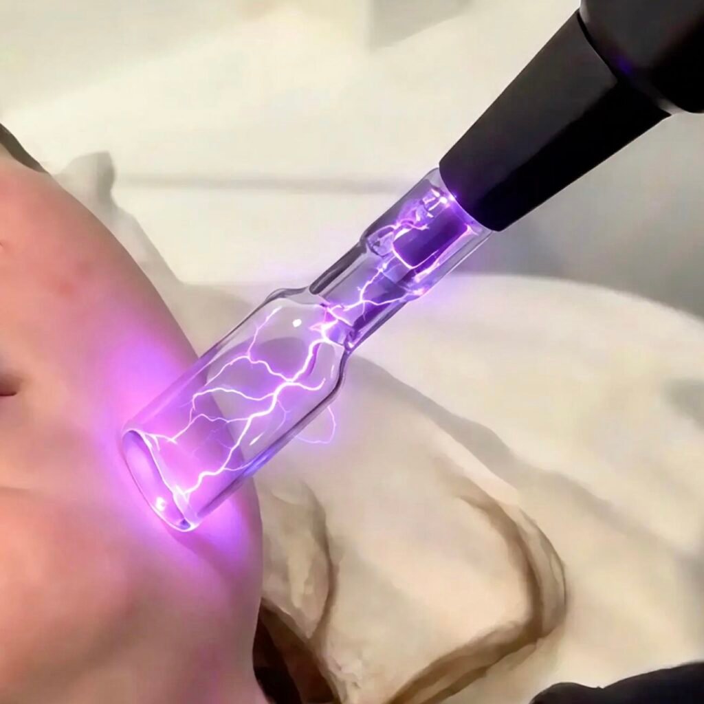 Cold plasma treatment: a violet plasma glass electrode glowing close to the skin of a client